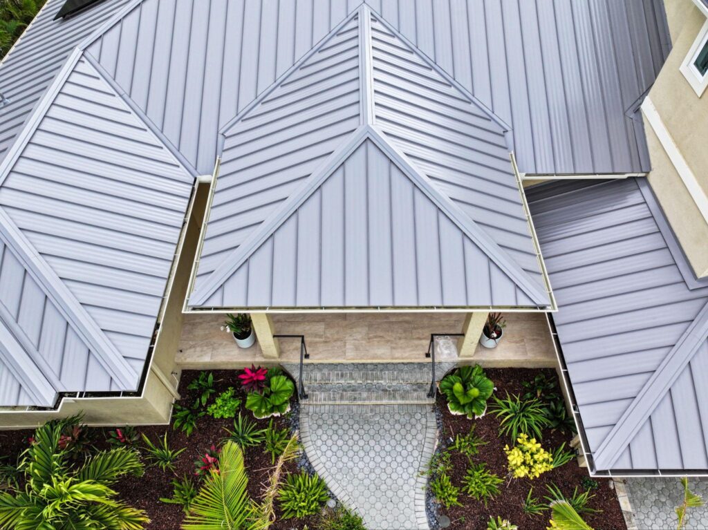 Direct overhead drone perspective of a luxury residential entryway featuring a grey slate-colored standing seam assembly, highlighting Metal Roofing Bradenton FL by Sunshine Metal Supply.