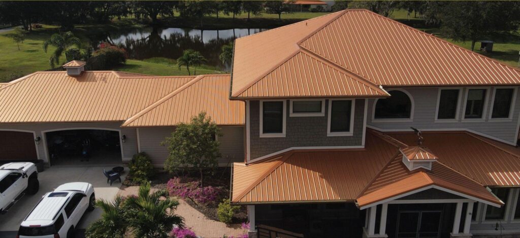 High-angle aerial photography of a luxury custom home with a bronze standing seam architectural finish, highlighting premium choices for Metal Roofing Naples FL by Sunshine Metal Supply.
